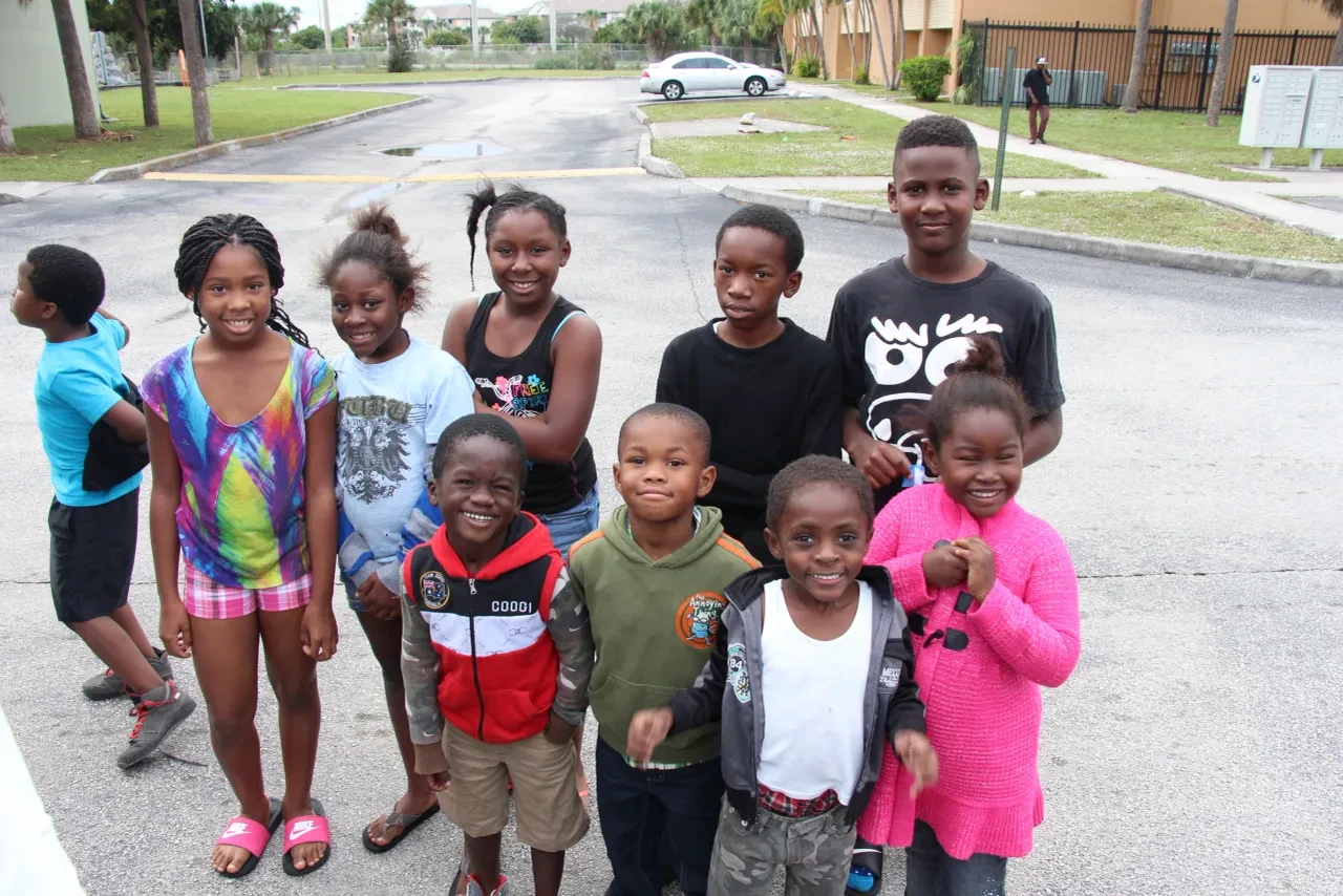 Group of children smiling together in parking lot at 2014 community event