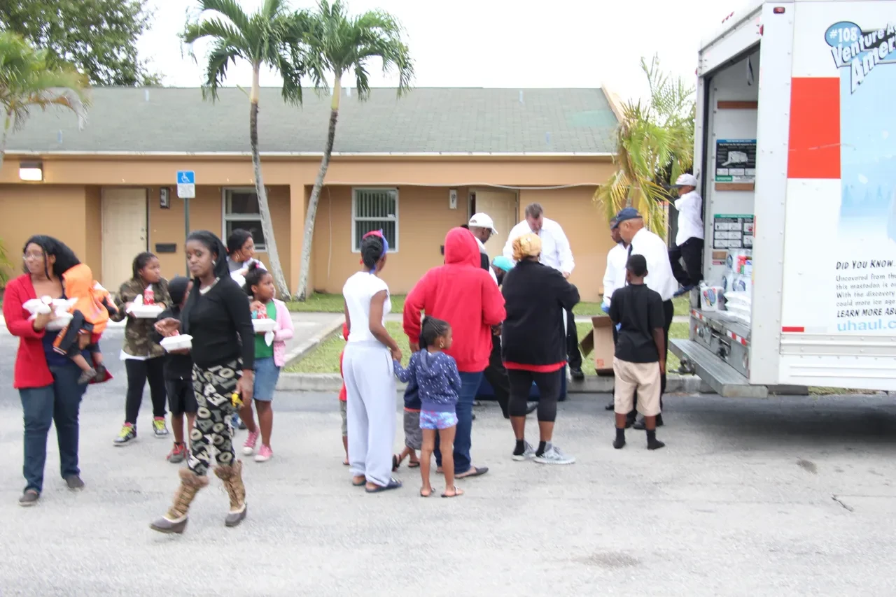 Large crowd gathered at U-Haul truck for community food distribution