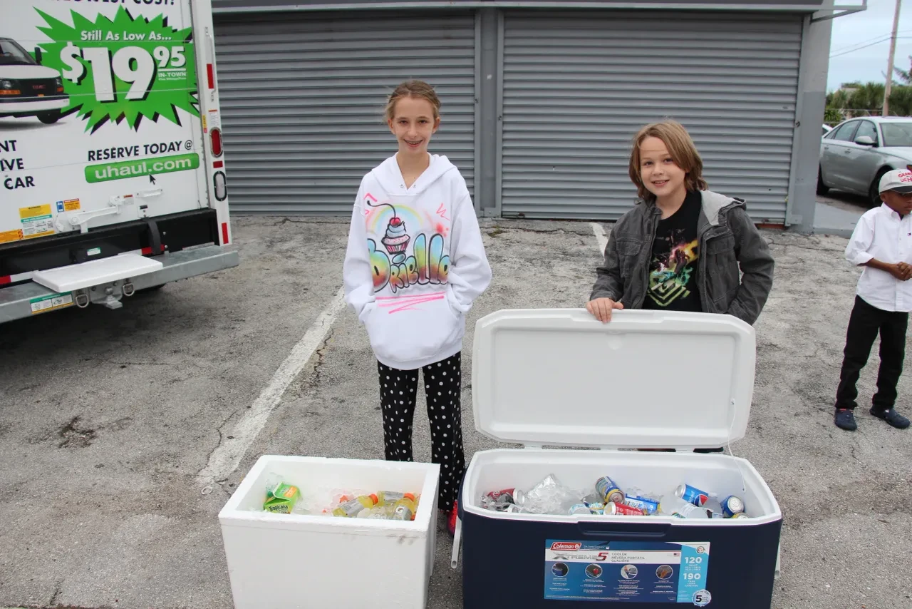 Two children with coolers at U-Haul community distribution event