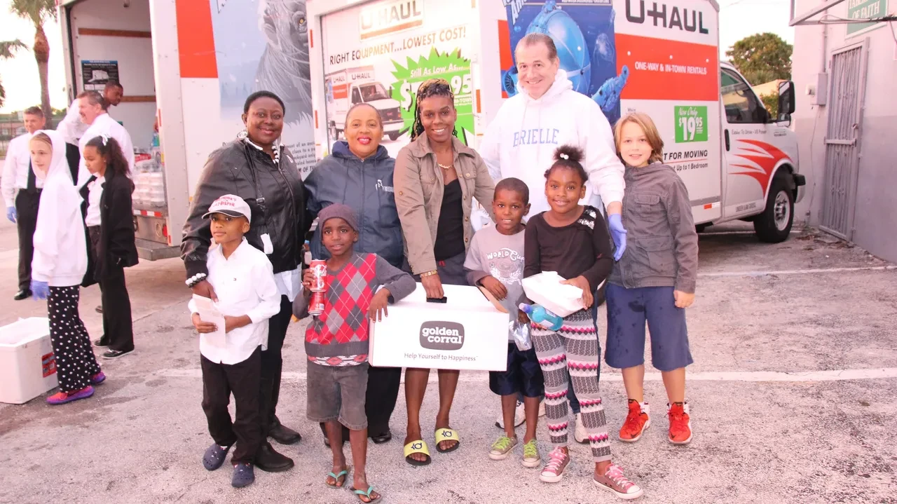 Group photo with children holding Golden Corral sign at U-Haul event