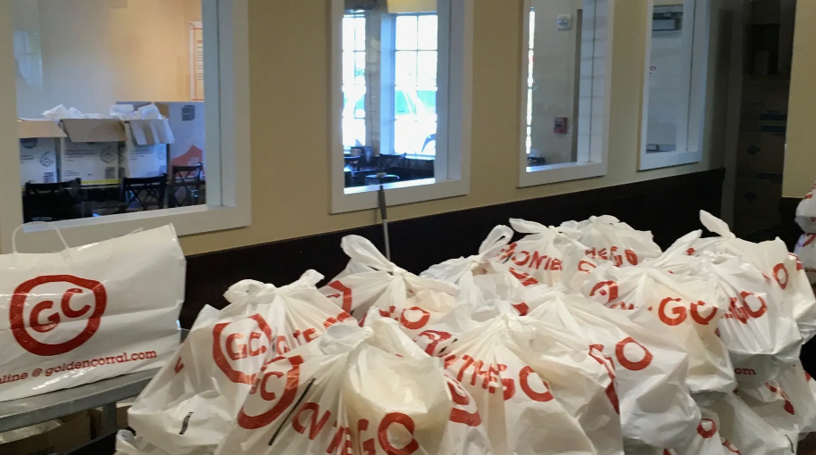 Rows of Golden Corral to-go bags lined up on counter inside restaurant