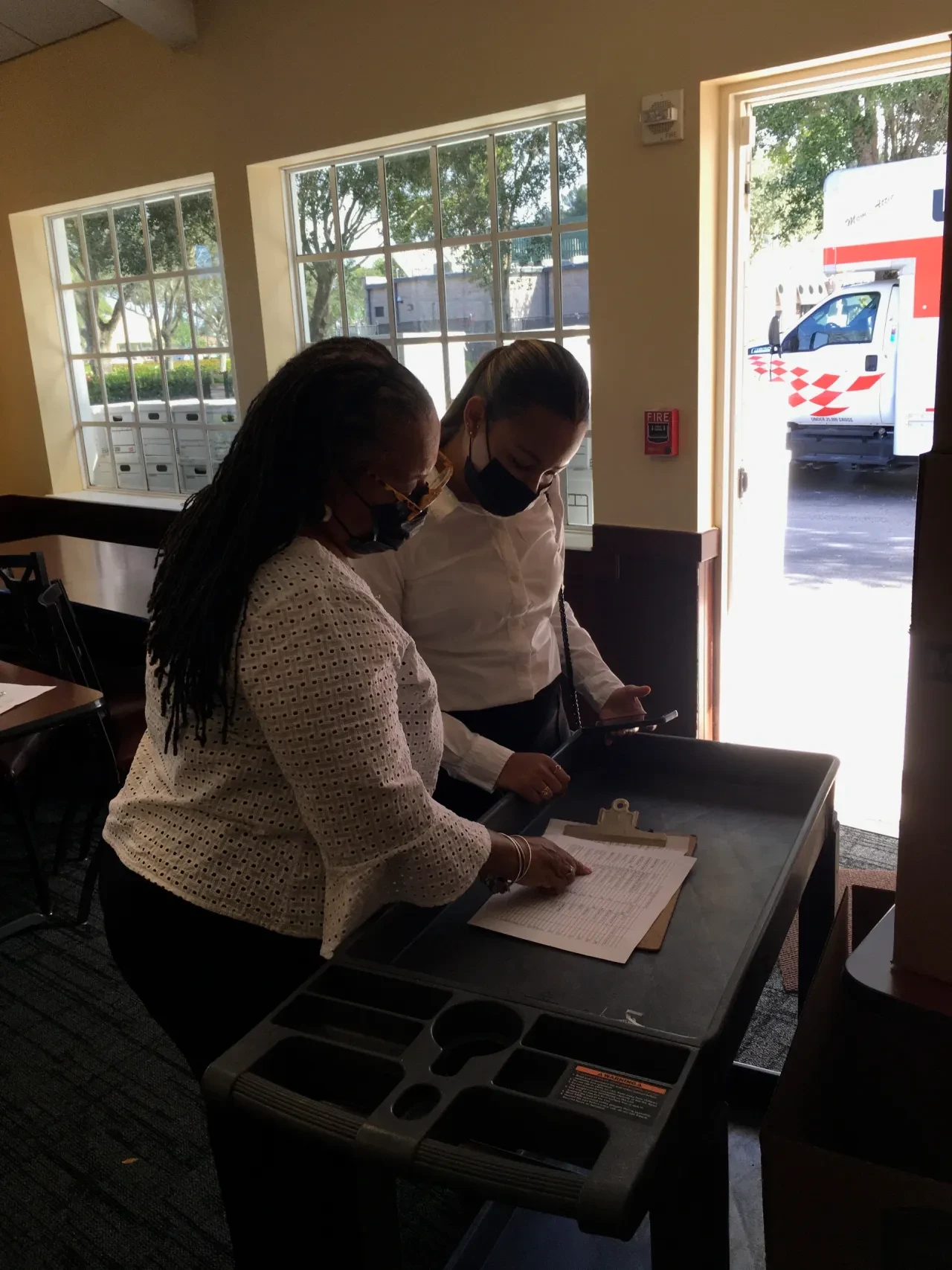 Two volunteers reviewing paperwork indoors at 2021 event