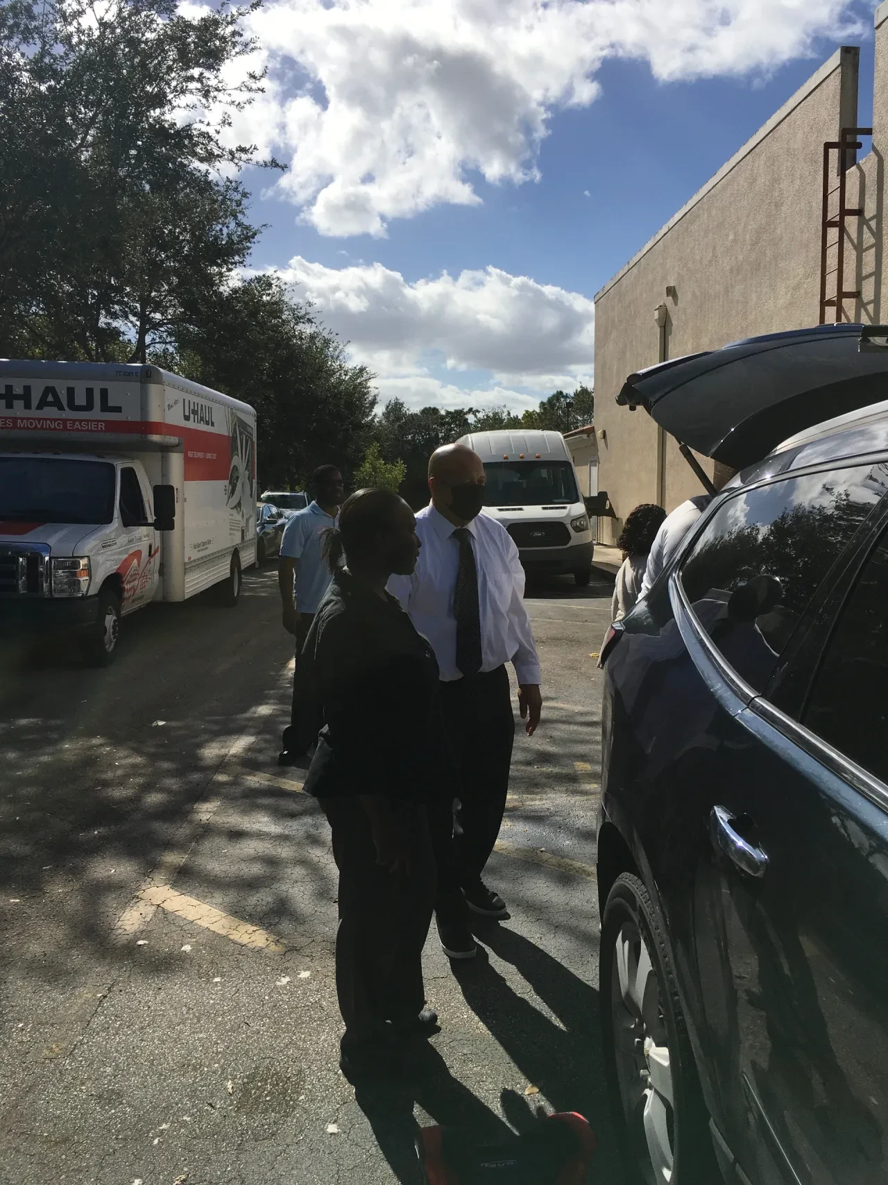 Volunteers talking in parking lot with U-Haul and transit van