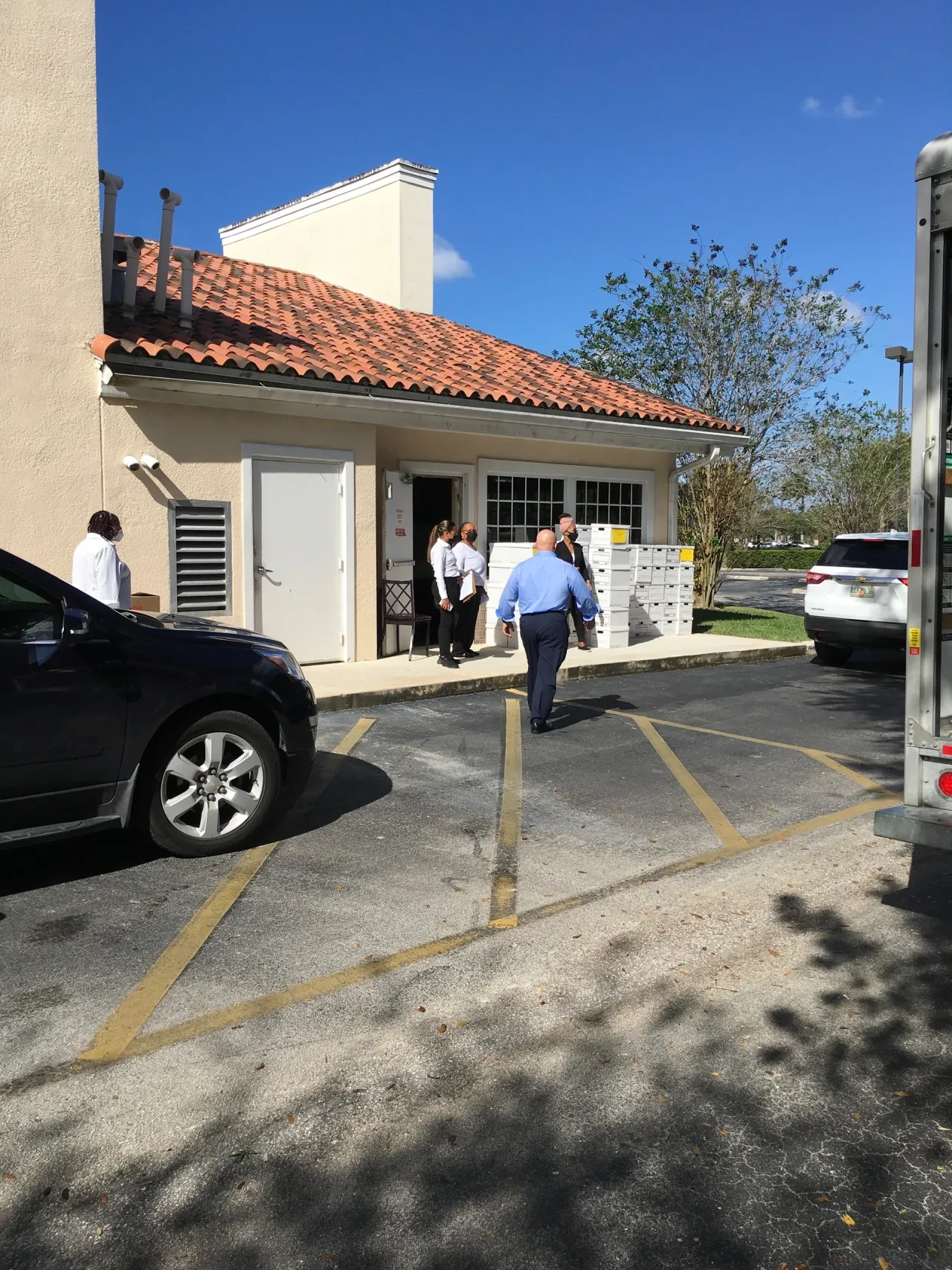 Volunteers and stacked boxes outside building back entrance