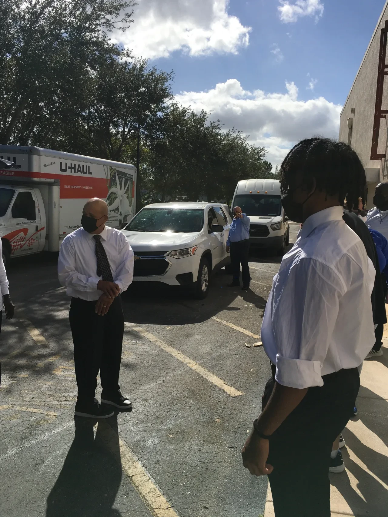 Volunteers gathered in parking lot with U-Haul and transit van