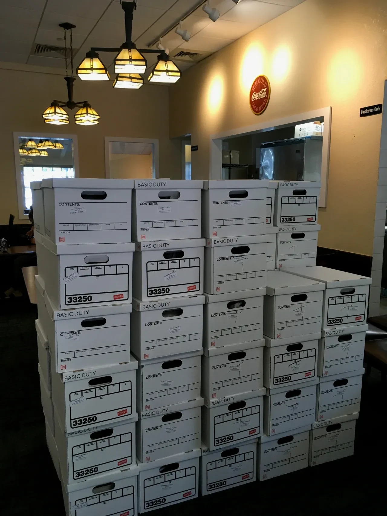 Large stack of labeled Basic Duty boxes inside restaurant