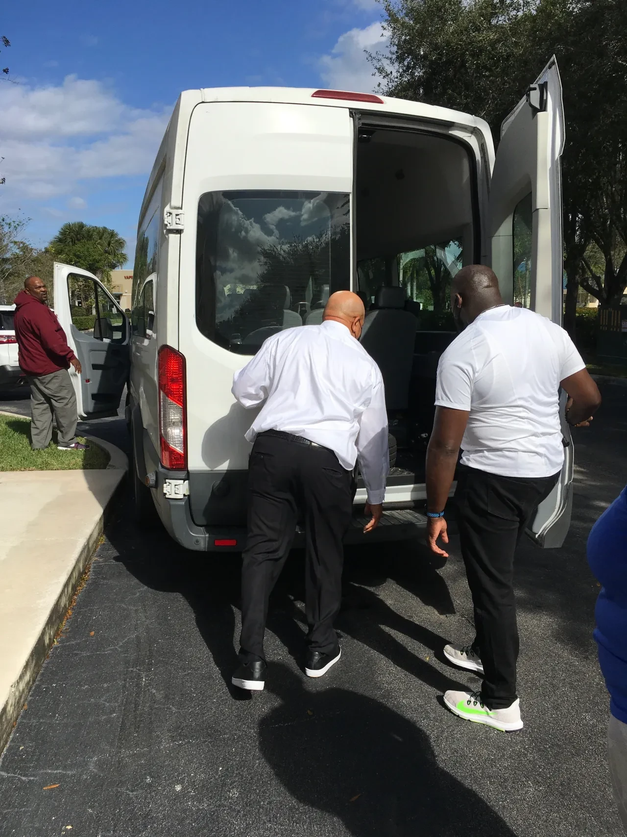 Two men loading boxes into white transit van