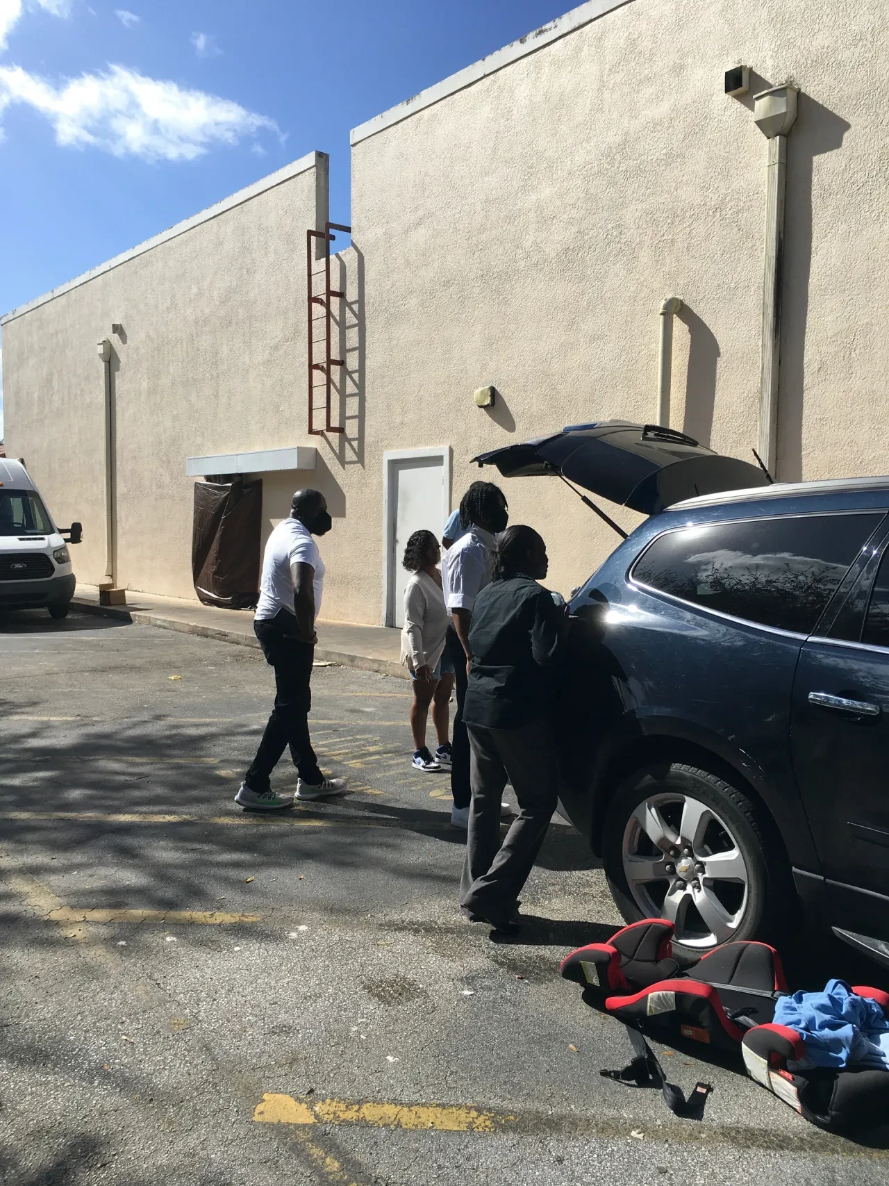 Volunteers unloading supplies from SUV in parking lot