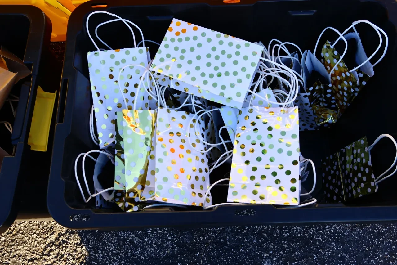 Crate of gold and green polka dot gift bags at outdoor community event