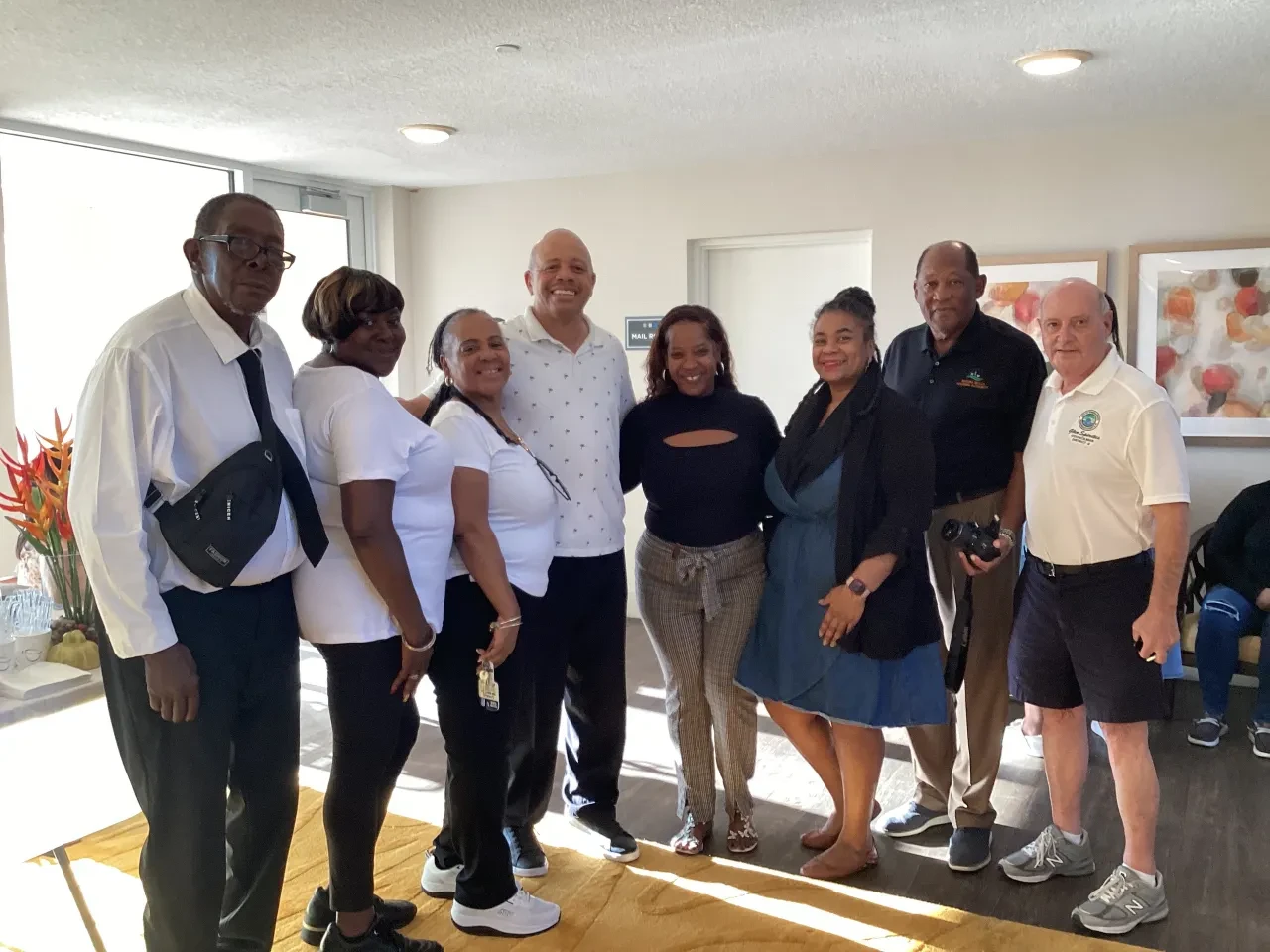 Eight volunteers posing together indoors at community outreach event