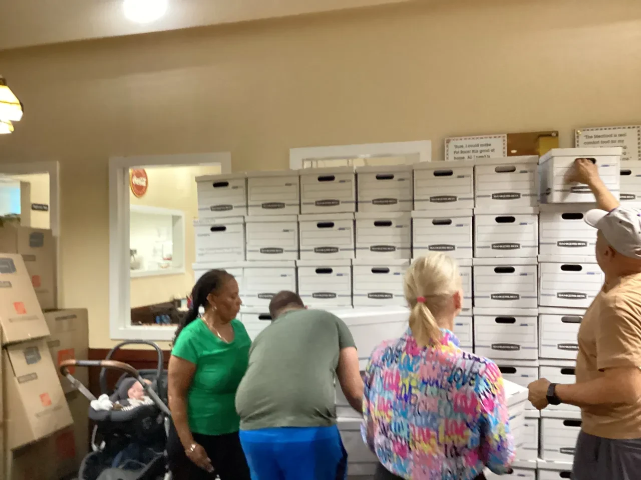 Four volunteers packing and organizing Bankers Boxes at indoor event