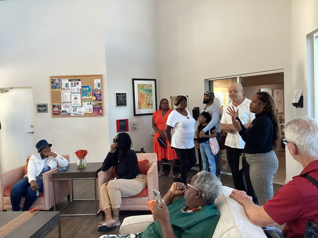 Community members gathered in bright indoor lounge at outreach event