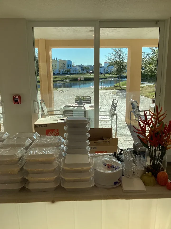 Stacked food containers and supplies on counter with waterfront view