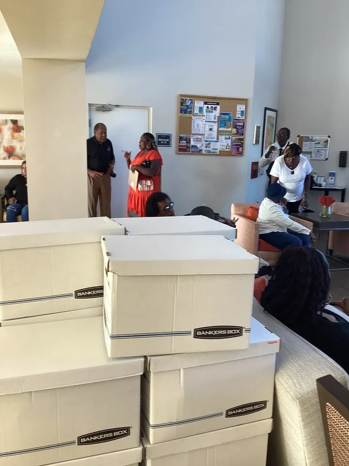Stacked Bankers Boxes in community center lobby with volunteers in background