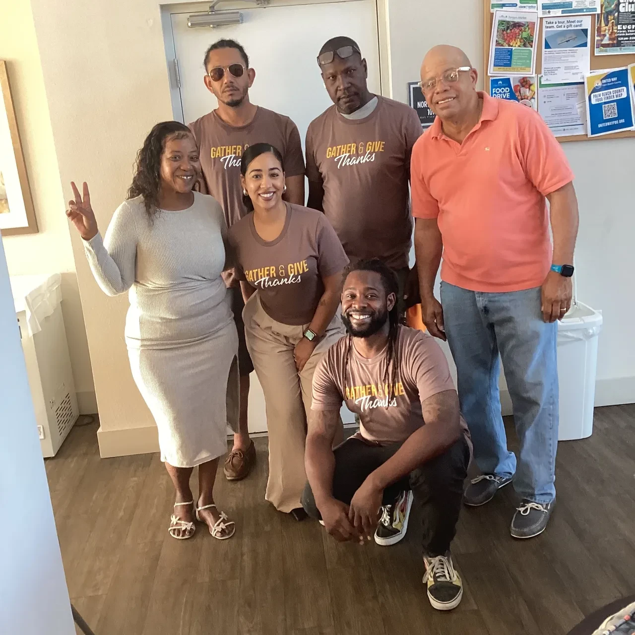 Group posing indoors wearing Gather & Give Thanks shirts