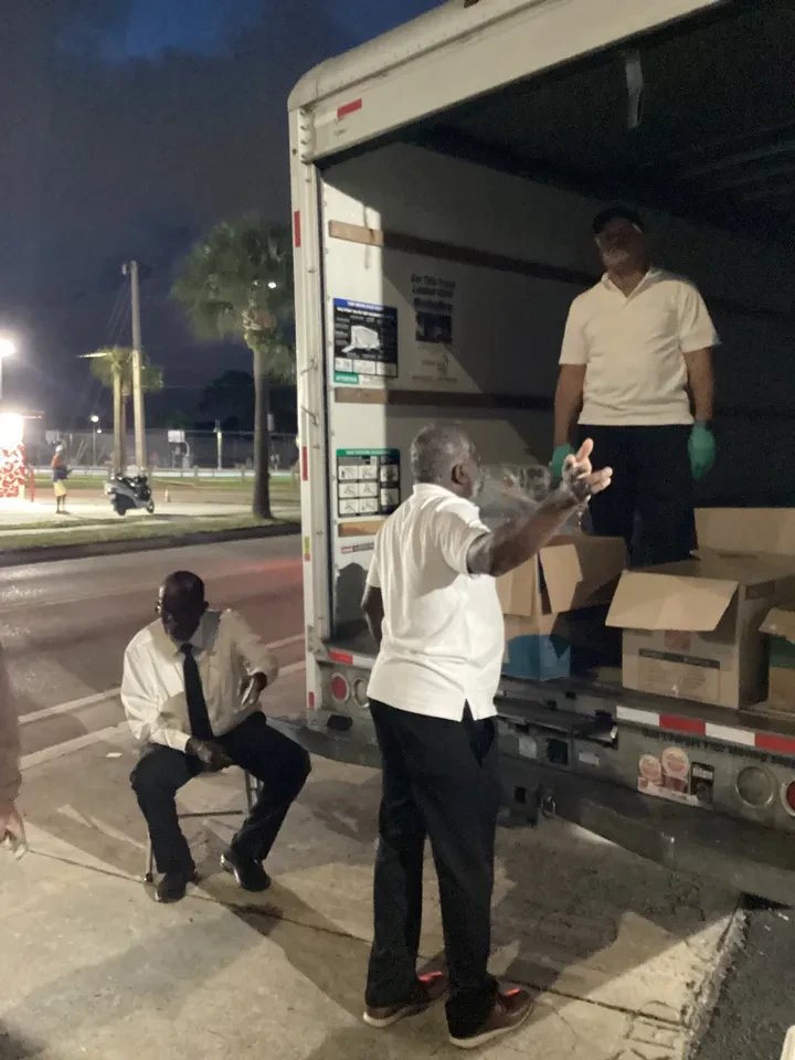 Volunteers unloading boxes from truck at night