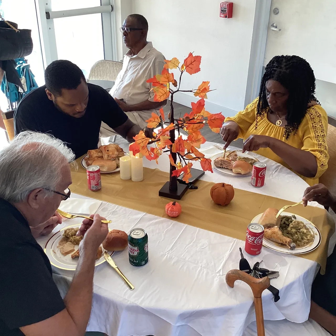Community members sharing Thanksgiving meal at decorated table