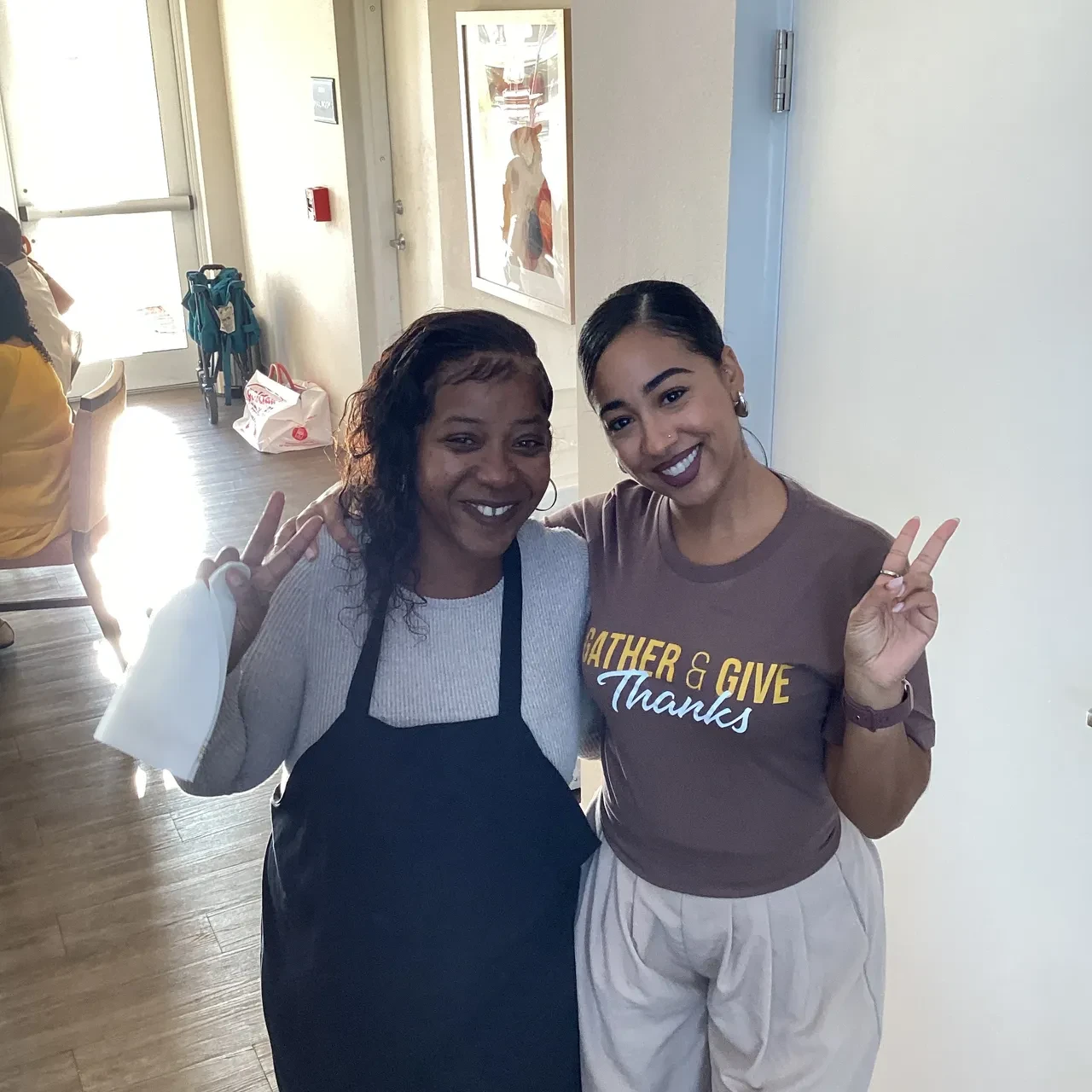 Two women posing together at indoor Gather & Give Thanks event