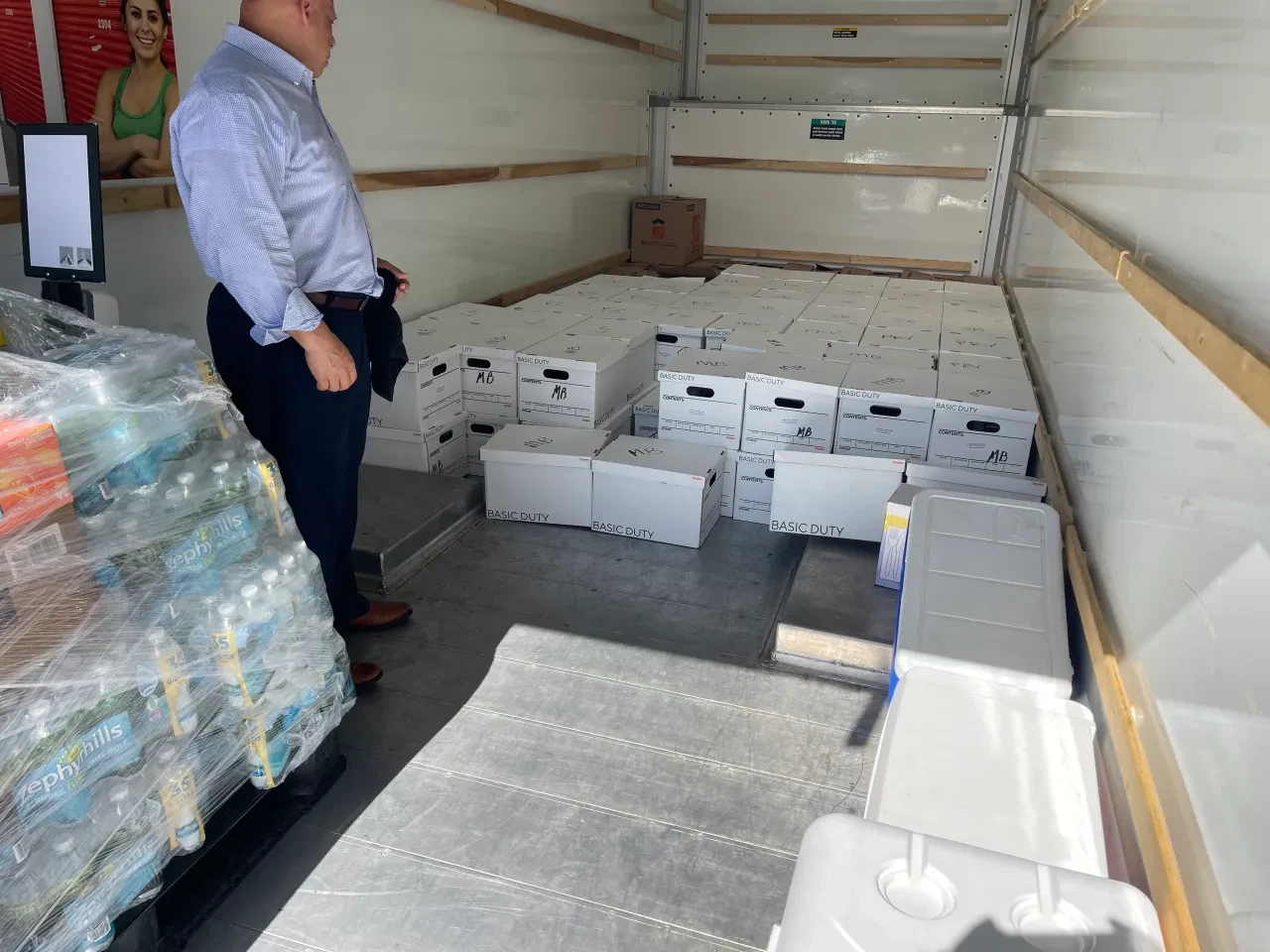 Volunteer overseeing boxes and water pallets in truck